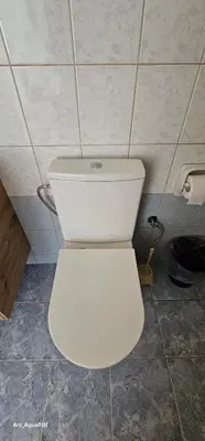 a white toilet in a bathroom with a roll of toilet paper at Pergamonto Apartments in Ayia Napa