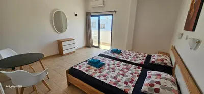 a bedroom with a bed and a table and a table and chair at Pergamonto Apartments in Ayia Napa