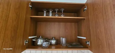 a cupboard with pots and pans on a shelf at Pergamonto Apartments in Ayia Napa