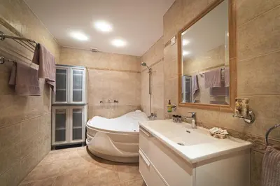 a bathroom with a tub and a sink and a mirror at Elite Seaside Apartment in Limassol