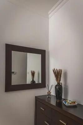 a mirror on a wall above a dresser in a room at Elite Seaside Apartment in Limassol
