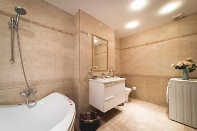 a bathroom with a tub and a toilet and a sink at Elite Seaside Apartment in Limassol