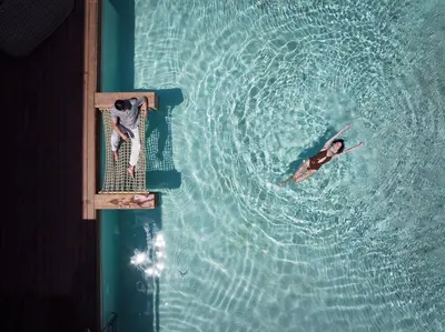 two people are swimming in the water in a pool at Aya Resort - Adults Only in Ayia Napa