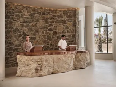 two men sitting at a stone counter with laptops at Aya Resort - Adults Only in Ayia Napa