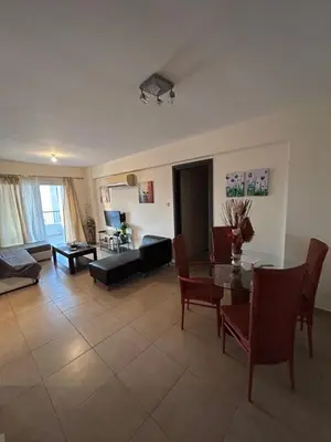 a living room with a table and a couch at Modern 2BR Appartment near Finikoudes beach - Larnaka in Larnaka