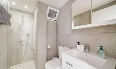 a bathroom with a shower and a toilet and a sink at Deluxe Apt - 500m Nissi Beach! in Ayia Napa