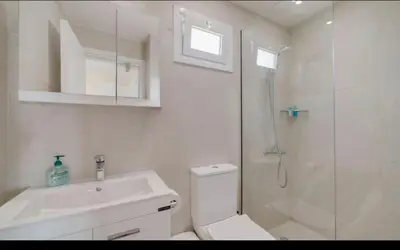 a bathroom with a shower and a toilet and a sink at Deluxe Apt - 500m Nissi Beach! in Ayia Napa