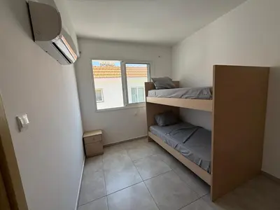 a small room with two bunk beds and a window at Sun & Sea House in Paralimni
