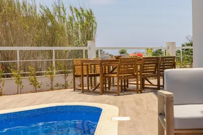 a patio with a table and chairs and a pool at Ayia Napa Bay View Villa 6 in Ayia Napa