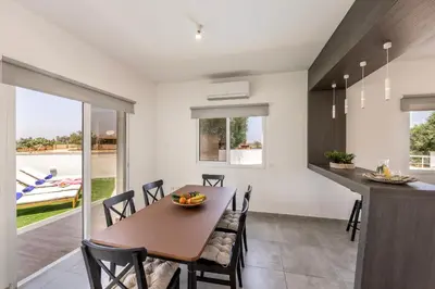 a dining room and kitchen with a table and chairs at Ayia Napa Bay View Villa 6 in Ayia Napa