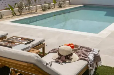 a hat sitting on a chair next to a swimming pool at Protaras Aqua Pearl Villa 3 in Protaras