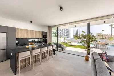 an open kitchen and living room with a table and chairs at Protaras Aqua Pearl Villa 3 in Protaras