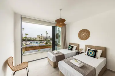 a hotel room with two beds and a balcony at Protaras Aqua Pearl Villa 3 in Protaras
