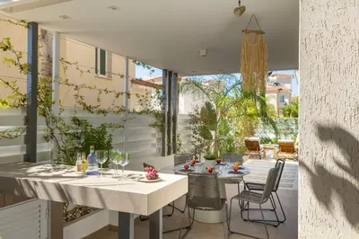 a dining area with a table and chairs and a patio at Protaras El Sol Villa in Protaras