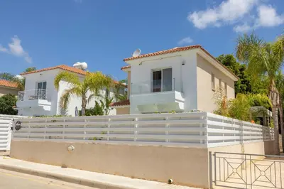 a white house with a fence in front of it at Protaras El Sol Villa in Protaras