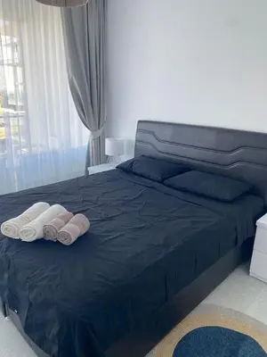 a bedroom with a blue bed with two towels on it at Abelia Sea View in Paralimni