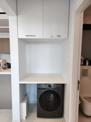 a laundry room with a washer and dryer under cabinets at Infinity Luxury Mansions in Yeri