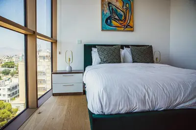 a bedroom with a white bed and a large window at Luxury 2BR Center 360 Nicosia with pool, gym, sauna in Nicosia