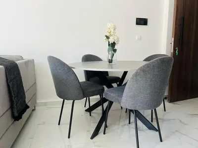 a white table with four chairs and a vase of flowers at Nicosia City Centre City Vibes Luxury 1BD in Nicosia
