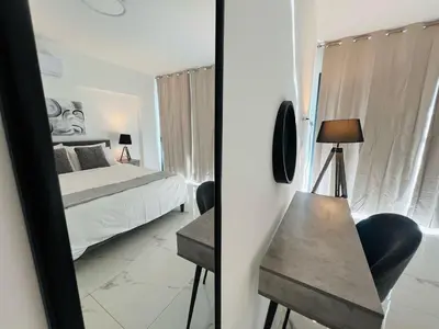 a bedroom with a bed and a table and a mirror at Nicosia City Centre City Vibes Luxury 1BD in Nicosia