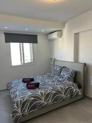 a bedroom with a bed with a zebra print blanket at Near Finikoudes Beach 3 in Larnaka