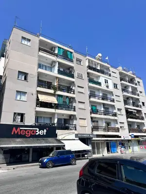 a large apartment building with a blue car parked in front at Near Finikoudes Beach 3 in Larnaka