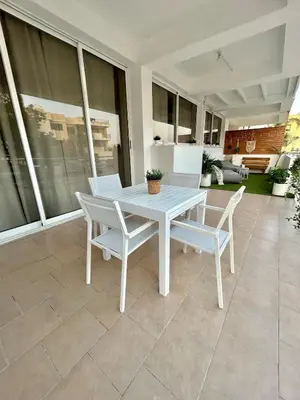 a white table and chairs on a patio at Seasons Retreat with pool and gym-2BR in Voroklini