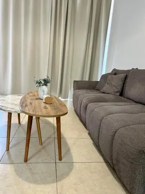 a living room with a couch and a table at Seasons Retreat with pool and gym-2BR in Voroklini