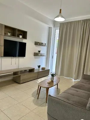 a living room with a couch and a tv at Seasons Retreat with pool and gym-2BR in Voroklini