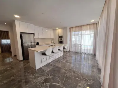 a kitchen with white cabinets and a counter with chairs at Panorama Luxury Summer Villa in Protaras