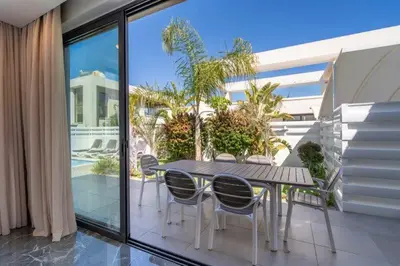 a table and chairs on the balcony of a house at Panorama Luxury Summer Villa in Protaras