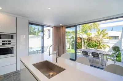 a kitchen with a large window and a table with chairs at Panorama Luxury Summer Villa in Protaras