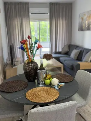 a living room with a table with a vase of flowers at Stylish 2BR in City Center of Limassol in Limassol