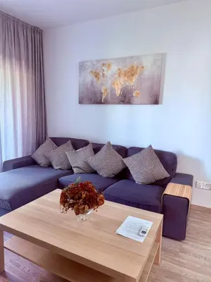 a living room with a blue couch and a table at Stylish 2BR in City Center of Limassol in Limassol