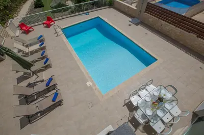 an overhead view of a swimming pool with tables and chairs at Protaras Mesogeios Villa Me16 Beachfront Villa in Protaras Center in Protaras