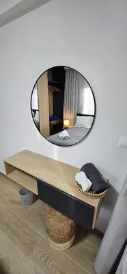 a mirror hanging on a wall above a table at Trendy Neapolis Beach Apartment in Limassol