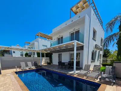 a villa with a swimming pool and a house at Nissi beach villa Azure in Ayia Napa