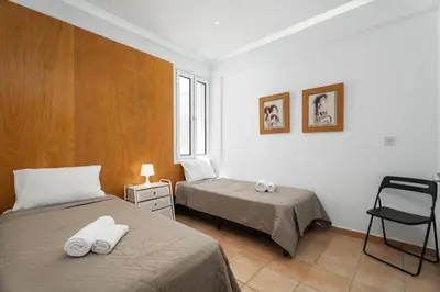 a bedroom with two beds and a chair at Villa Zina by Ezoria Villas in Meneou