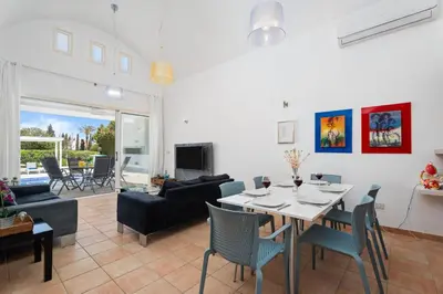 a dining room and living room with a table and chairs at Villa Zina by Ezoria Villas in Meneou