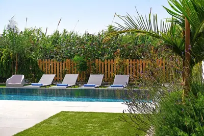 a row of lounge chairs next to a swimming pool at MAREN - 250m from Golden Sandy Beach in Paralimni