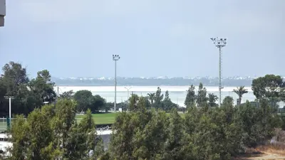 a view of a field with trees and the water at Charming 2BR Classic Flat with Fast Wi-Fi in Larnaka