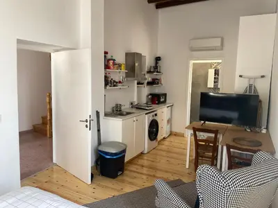 a living room with a television and a kitchen at ToHaniMou - Kamara Medium Studio in Nicosia