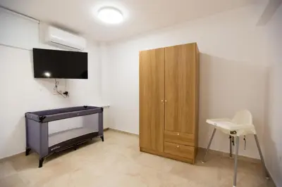 a bedroom with a bed and a cabinet and a tv at Nadine sea side villas in Larnaka