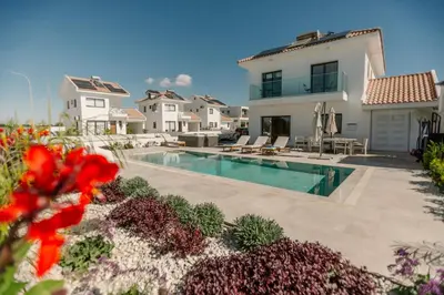 a villa with a swimming pool and a house at Nadine sea side villas in Larnaka