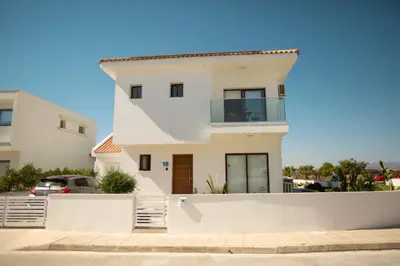 a white house with a white wall at Nadine sea side villas in Larnaka