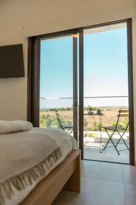 a bedroom with a bed and a balcony with a view at Nadine sea side villas in Larnaka
