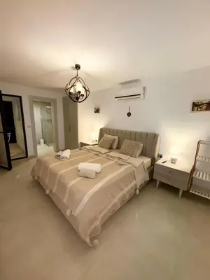 a bedroom with a large bed and a chandelier at 3 bedrooms villa with own pool!