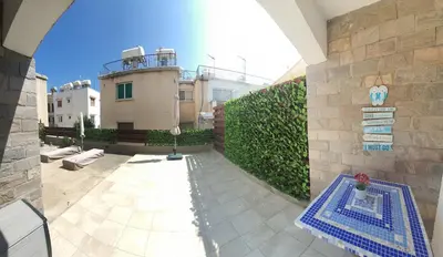 a view of a patio with a building in the background at Lovely ground floor apartment with BBQ in Aglantzia