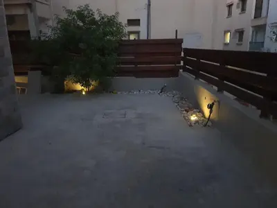 an empty courtyard with a tree in a building at Lovely ground floor apartment with BBQ in Aglantzia
