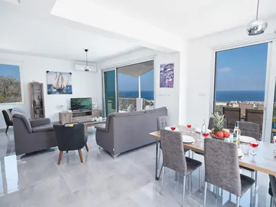 a dining room and living room with a table and chairs at Villa Clea,stunning 4bdr Protaras Villa, Seaviews in Protaras